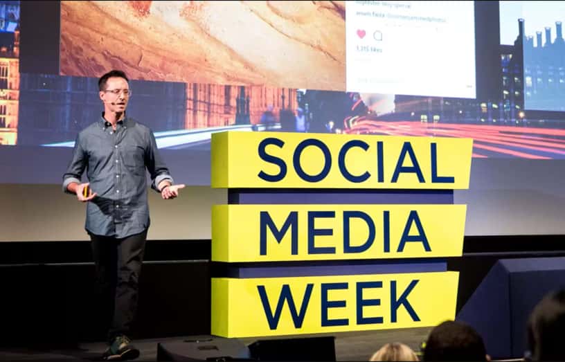 Man on stage discussing social media week