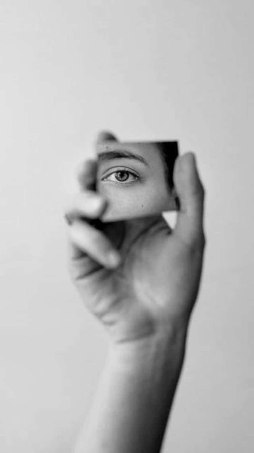 une image en noir et blanc pour Instagram Reels montrant une main qui tient un miroir