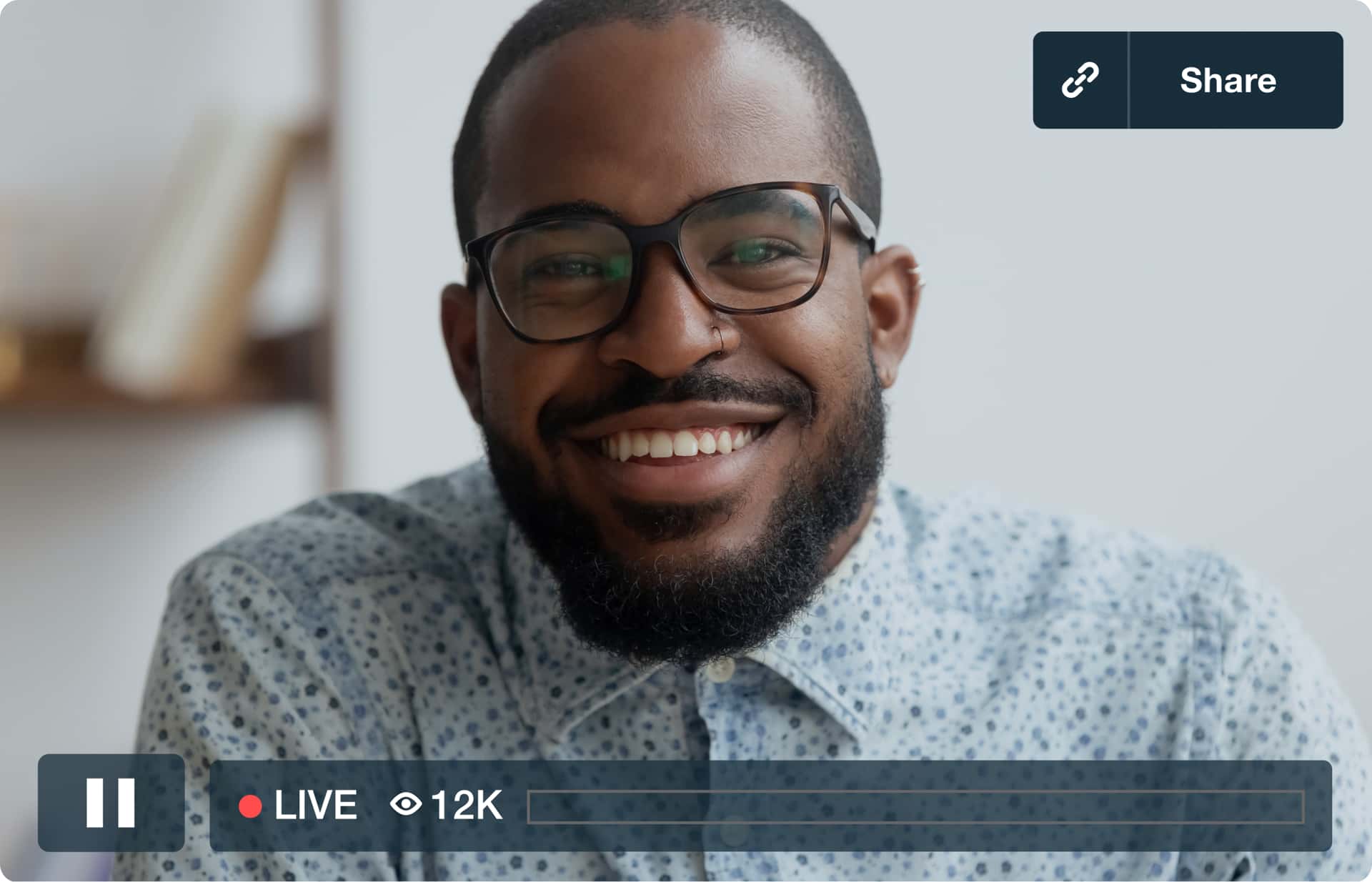 A man with glasses smiles at the camera during a live stream