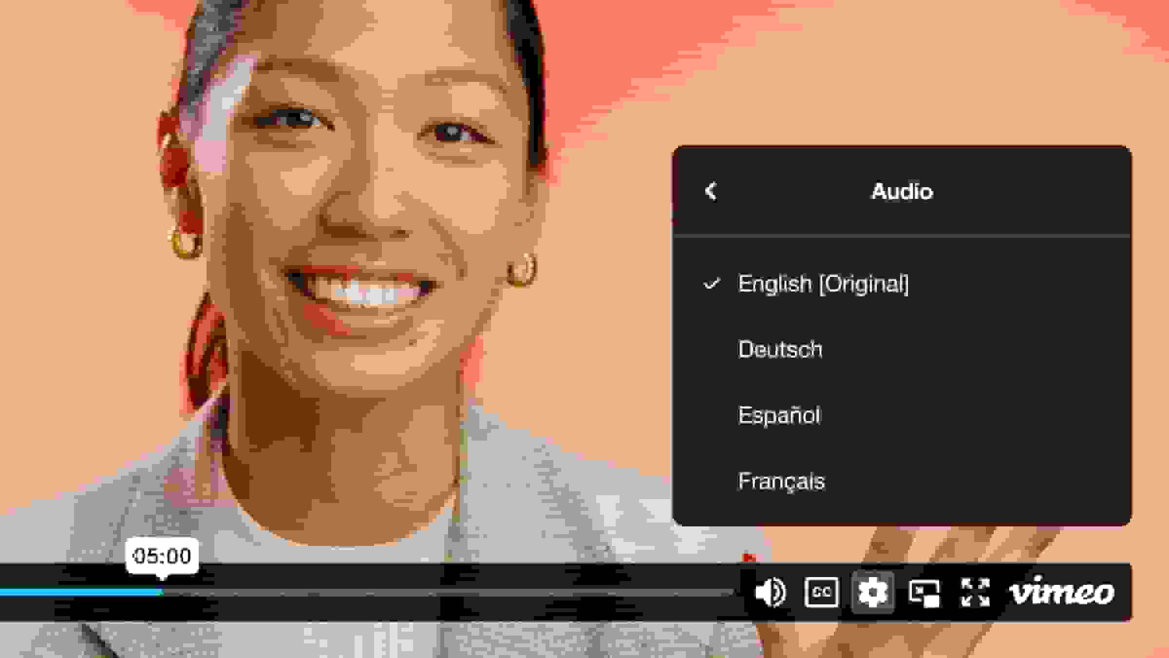 Add audio to video of a smiling woman, with a choice between different language audio such as English and Spanish.