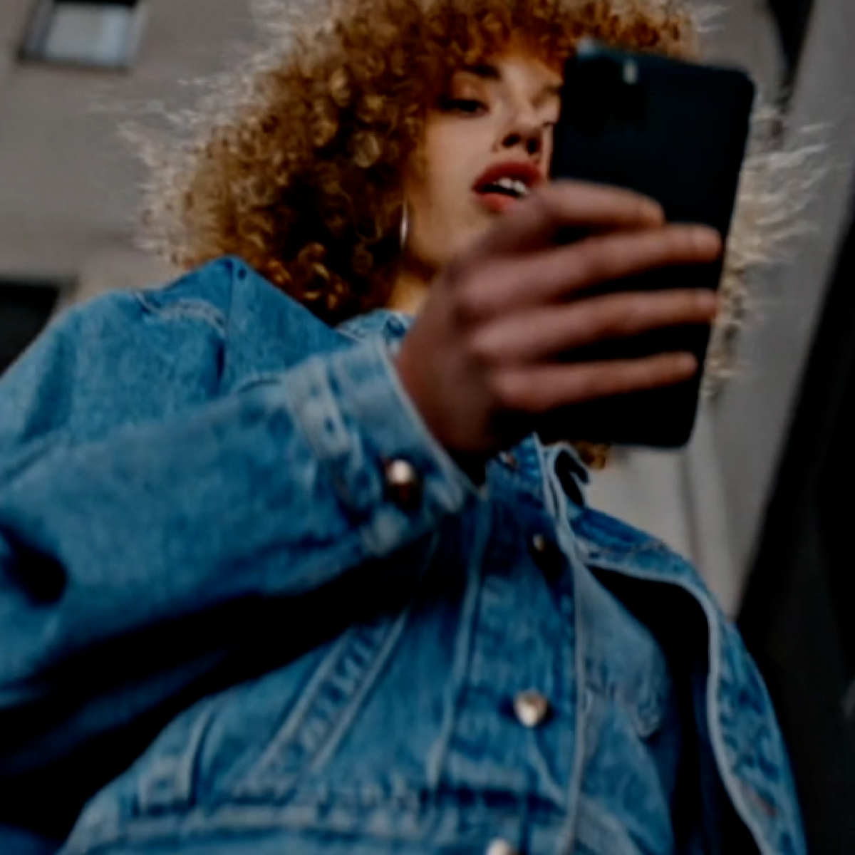 Woman using a video creating, editing, and hosting platform on her smartphone