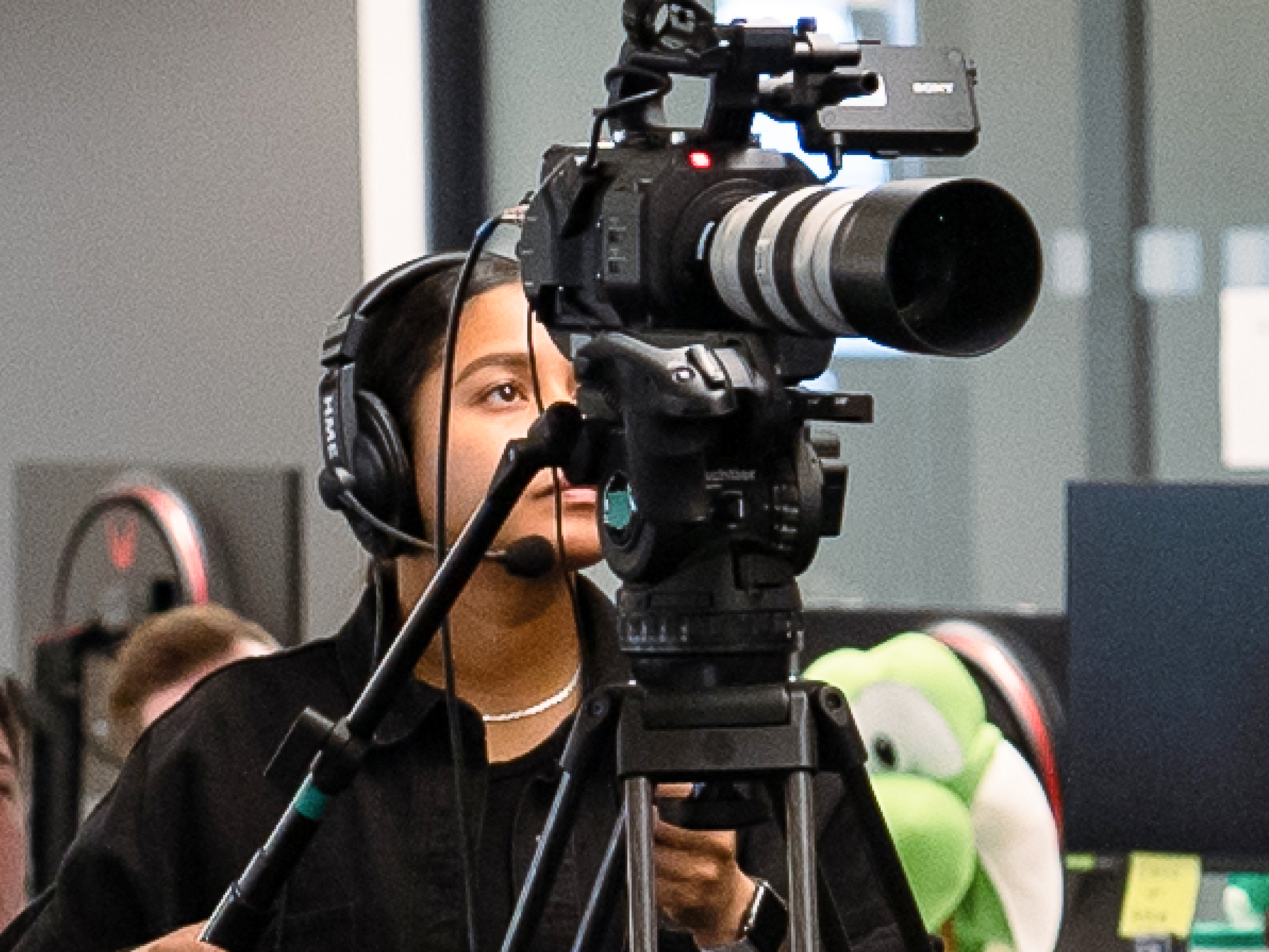 A professional filming a scene with a recording device