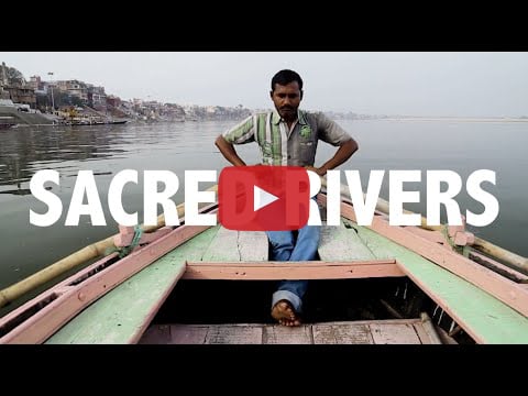 A video thumbnail of a man sitting in a boat. There is white text that says "Sacred Rivers."