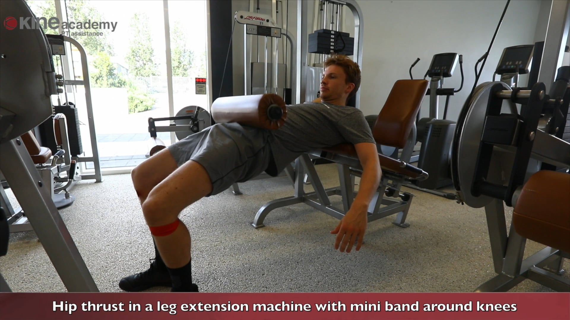 Hip thrust in a leg extension machine with mini band around knees.mp4