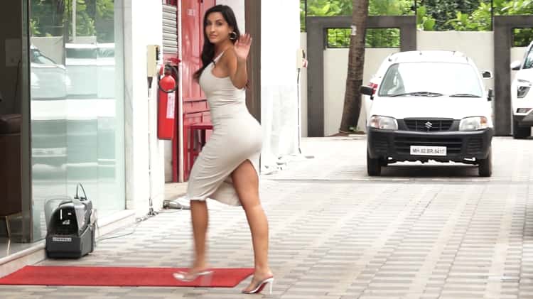 Nora Fatehi drives up in a white Mercedes wearing a white bodycon