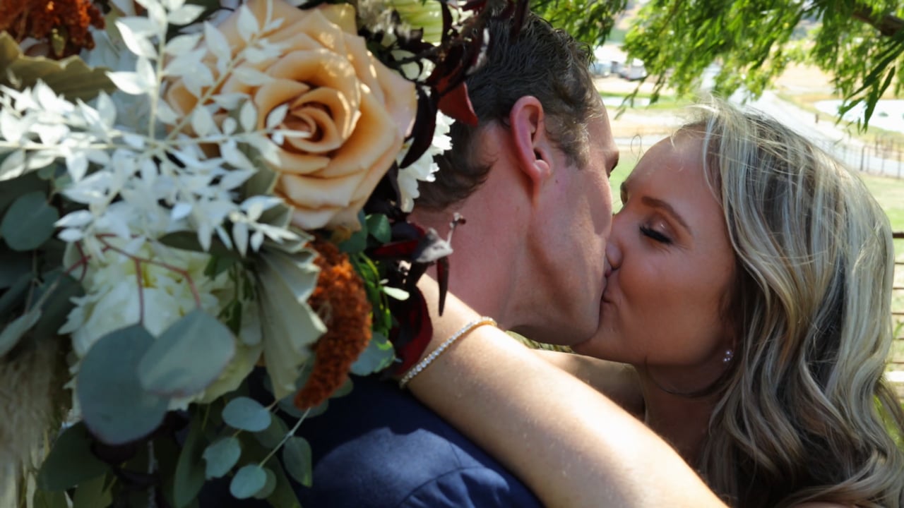Couple sharing a kiss behind a bouquet