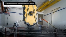 Image of the James Webb Space Telescope in a clean room. A gray box in the top left corner has text that reads "A New Age in Astronomy: The James Webb Space Telescope." Text at bottom reads "The James Webb Space Telescope is the largest telescope we've ever sent into space."