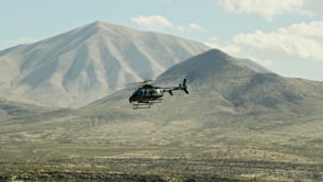 Helicopter aerial filming past desert mountains