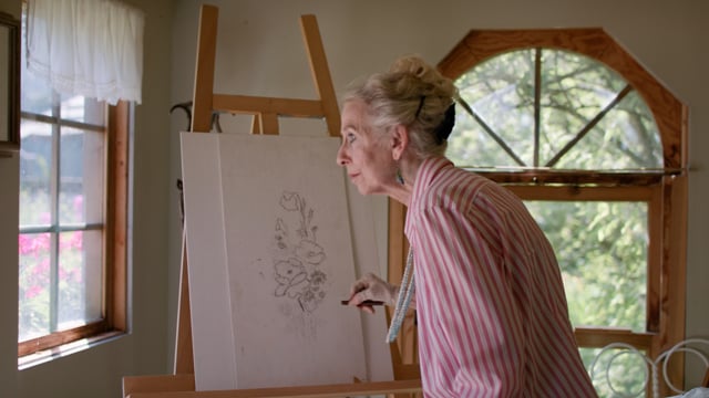 Art and relaxation. Beautiful and talented senior woman sketches on canvas. Enjoying her retirement and following her dream.