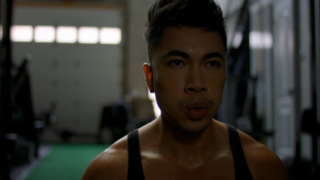 Intense ab workout by athletic asian man in a modern gym. 