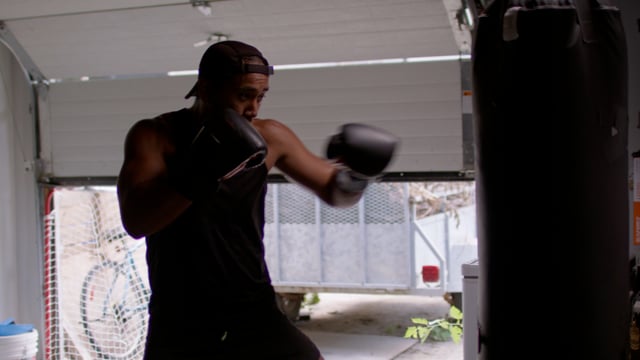 A Boxer hits the pads hard during an intense workout.