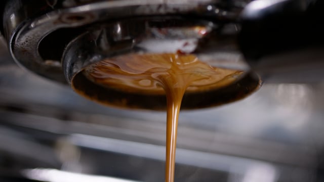 The crema forms in beautiful espresso machine brewing a rich fresh cup of espresso.