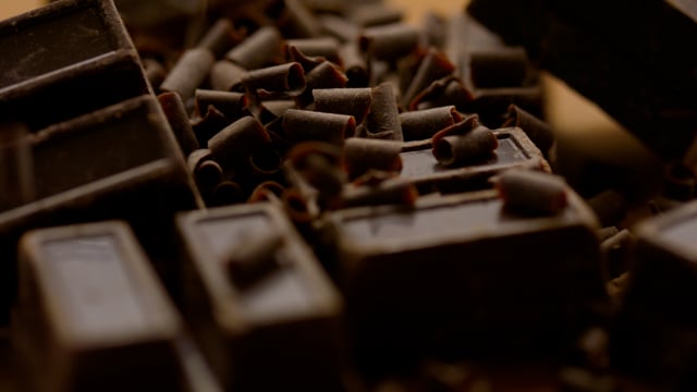 Decadent blocks of artisanal chocolate tumble in slow motion.
