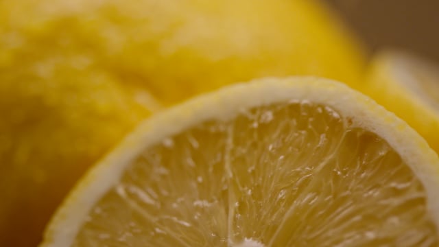 Macro shot of fresh cut organic lemons being misted on the cutting board. 