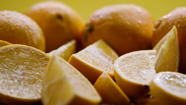 Sweet and juicy slices of fresh cut lemon falling in slow motion. 