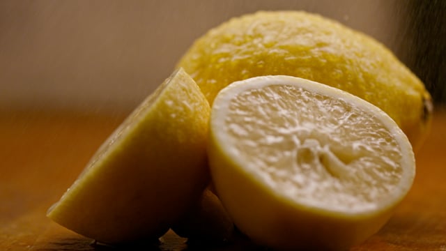 Fresh cut organic lemons being misted on the cutting board. 