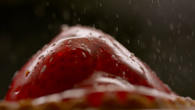 Finishing off a freshly baked strawberry tart with a dusting of sweet icing sugar.