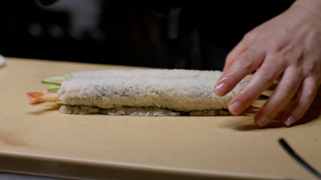 Cutting sushi roll. Creating amazing sushi and sashimi at a high-end sushi restaurant.
