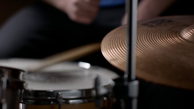 Drummer riding the high-hat cymbal during a drum session. 