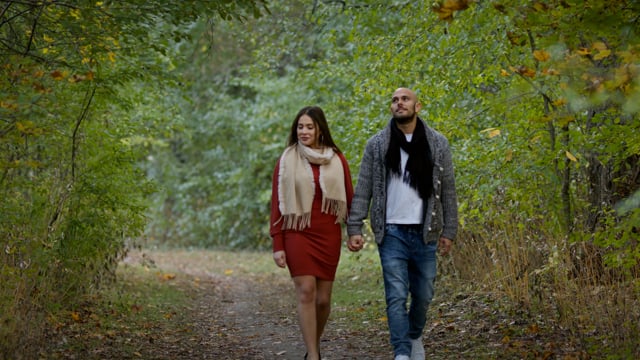 A beautiful young couple in love, hiking through the changing colours of an autumn backdrop. 