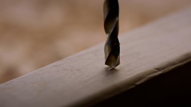 Drilling a hole through a piece of wood for a construction project. 