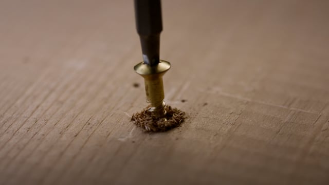 Driving a screw into a piece of wood with a drill for a construction project. 