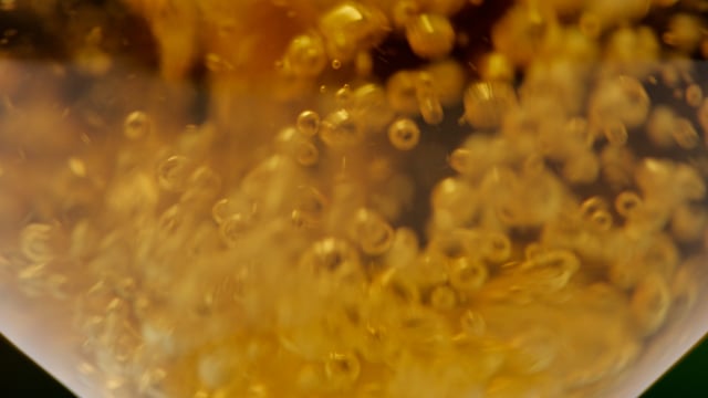 Beer poured into transparent glass in slow motion.