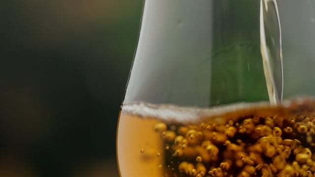 Lager beer in transparent glass in slow motion.
