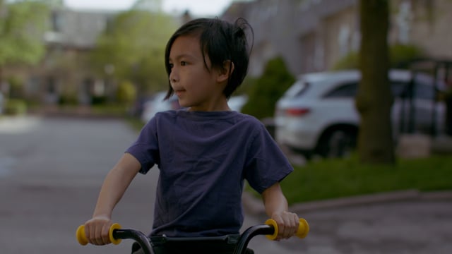 A young child learns to ride his bike.