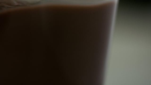 Chocolate Milk pouring into glass closeup in slow motion.