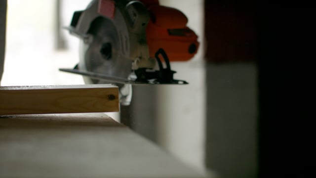 Cutting a piece of wood with an electric saw for a construction site. Home improvements.