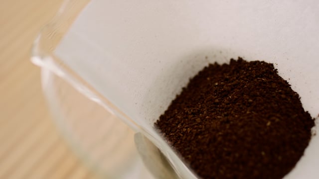 Ground and roasted coffee beans placed into Pour Over coffee maker.