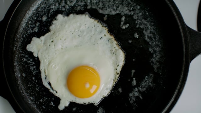 Sunny side up morning breakfast. Egg frying on a cast iron pan. 