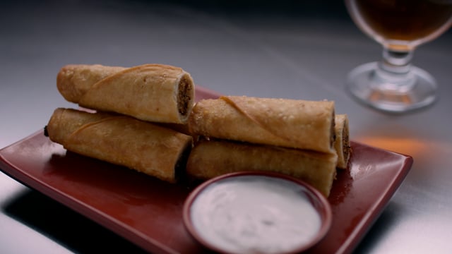 Pub food product shot. Taquitos on a plate ready to be eaten. Delicious and flavourful snacks.