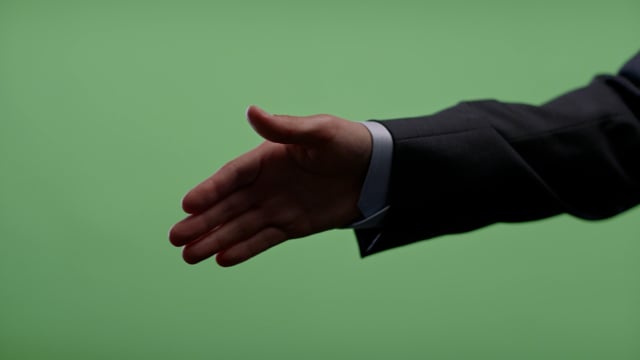 Businessman handshake on green screen.