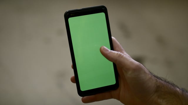 Man typing on a green screen smartphone. Technology footage. Great for close-up scenes.