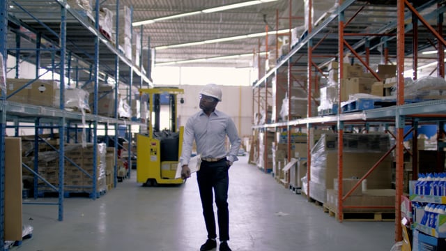 A manager walks through ecommerce warehouse. Back to work and business is booming.