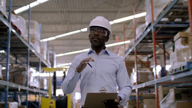 Ecommerce manager looks over inventory and logistics in a warehouse facility. 