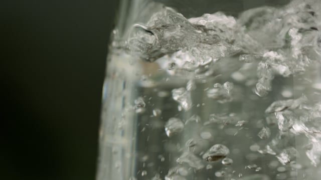 Champagne filling glass at 120fps, macro close-up. 