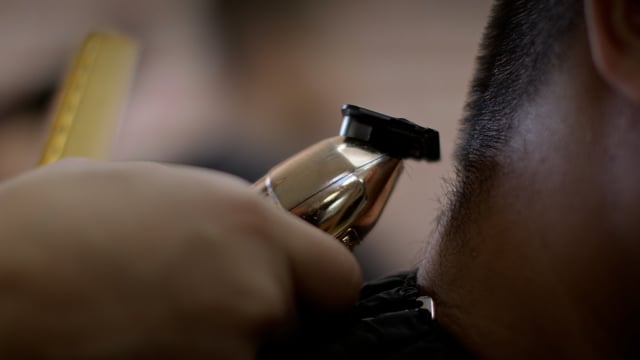 A close shave. Getting edges for a haircut just right at a hip barber shop.