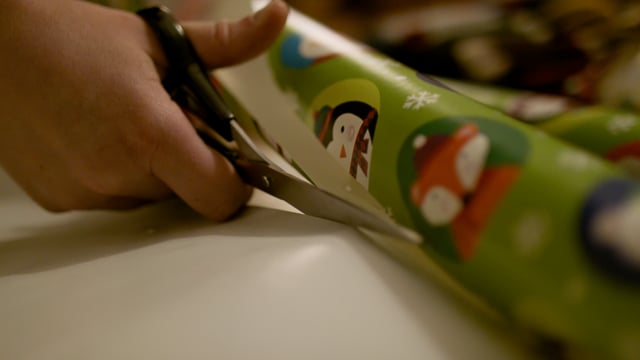 Cutting wrapping paper and wrapping presents for the holidays. 