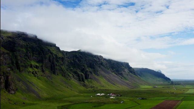 Clouds roll above cliffside of gorgeous Iceland's natural beauty. 