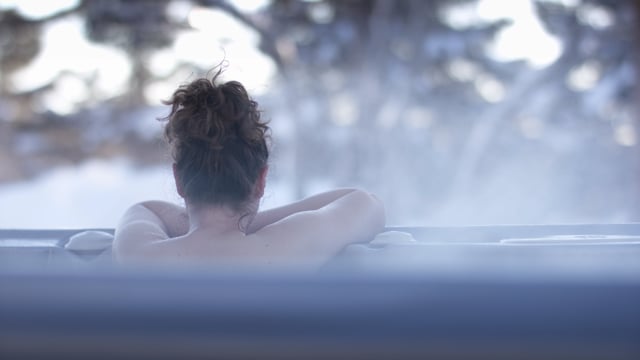 A nordic spa winter retreat. Enjoying the beauty of nature in a hot tub.
