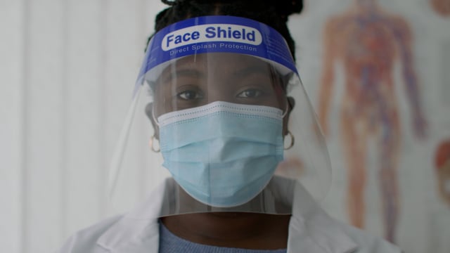 Portrait of a young black female doctor. Covid mask and shield.