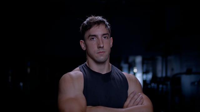 Strong and intense portrait of a focused and determined male athlete at the gym.