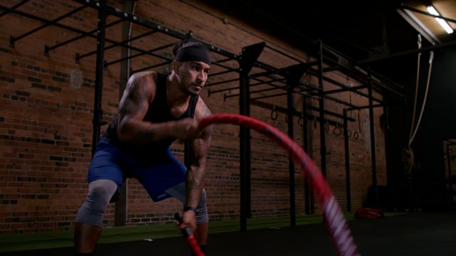 Focus on your goals! An athlete uses power and speed to exercise. Ropes in a gym working arms. 