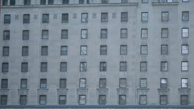 Wall of apartment windows in downtown urban hotel.