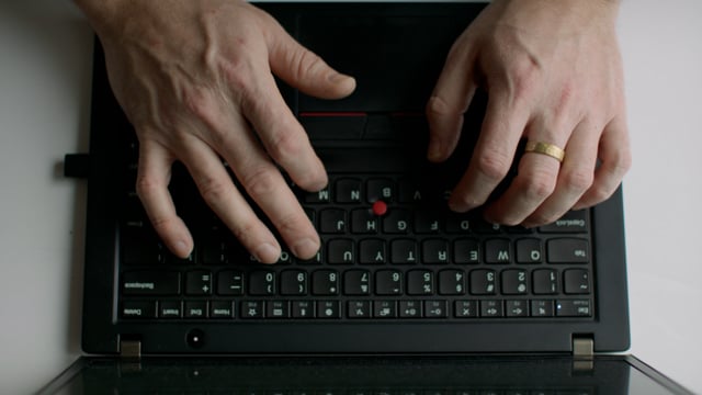 Man typing on a laptop keyboard. Closeup of a typing process on a black laptop. 