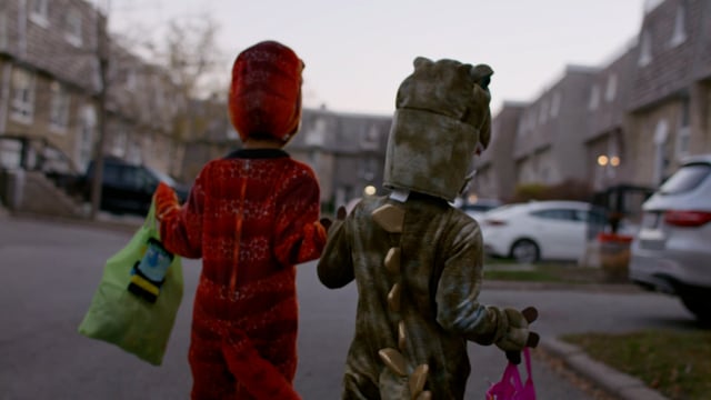 Cute kids, brothers in halloween costumes out trick or treating.