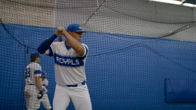 Athletic baseball player practicing his swing in a training facility. 